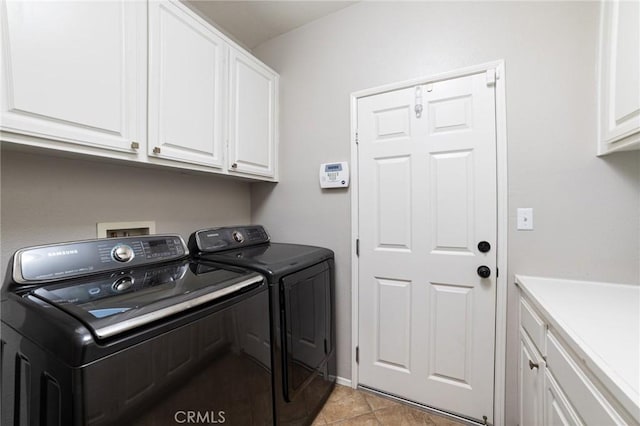 washroom featuring light tile patterned floors, separate washer and dryer, and cabinet space