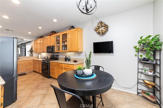 kitchen featuring glass insert cabinets, light countertops, visible vents, and black appliances