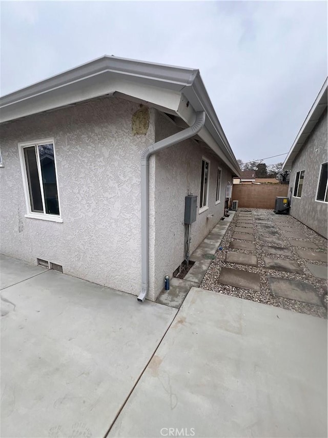 view of home's exterior featuring a patio area, fence, cooling unit, and stucco siding