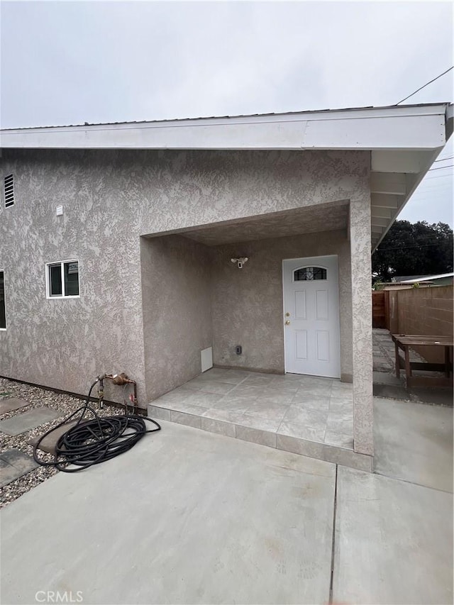 doorway to property with a patio area and stucco siding