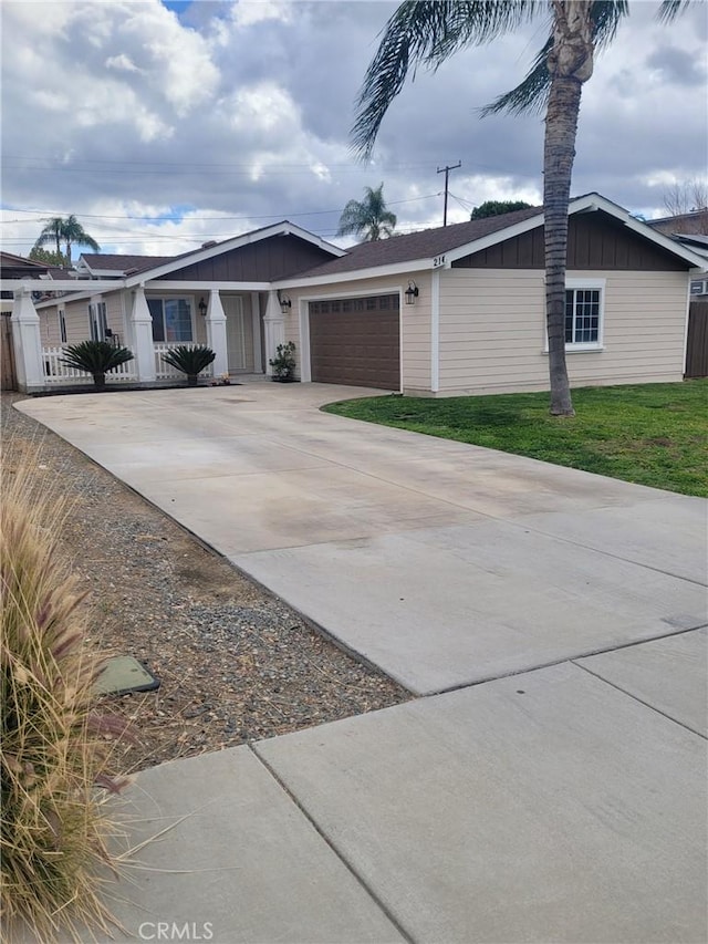 single story home with a garage, concrete driveway, fence, a front lawn, and board and batten siding