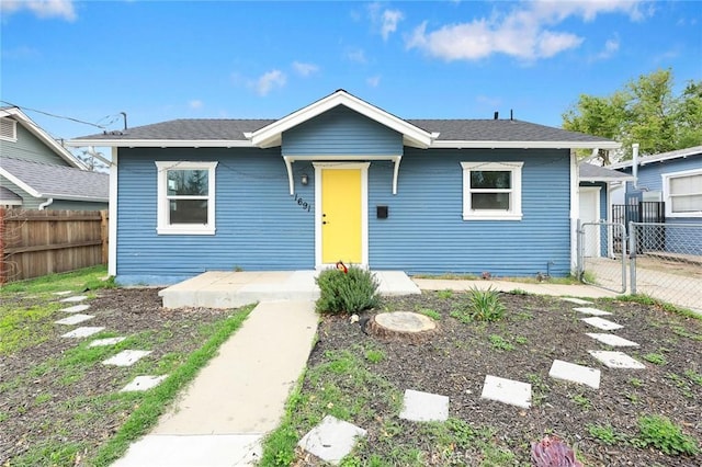 bungalow featuring a gate and fence