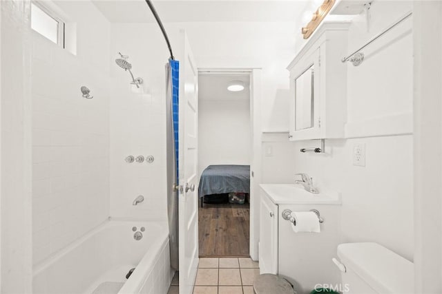 ensuite bathroom featuring tile patterned flooring, toilet, connected bathroom, a sink, and shower / bath combination with curtain