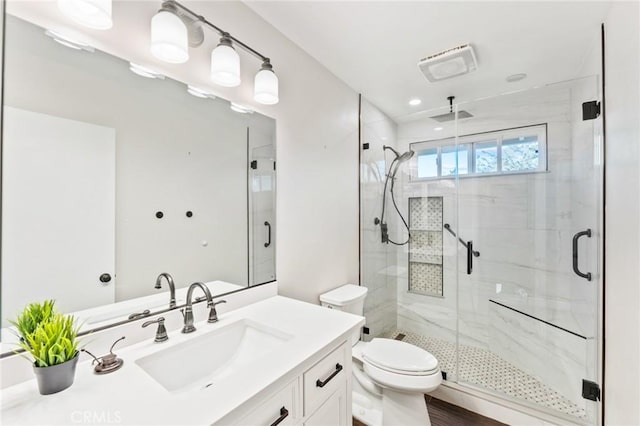 full bath with vanity, a shower stall, and toilet