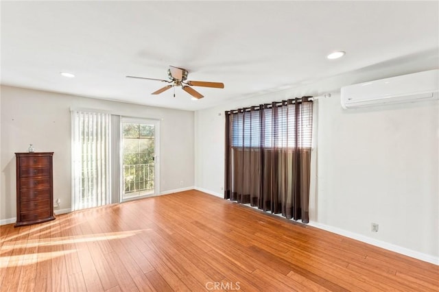 empty room with baseboards, ceiling fan, wood finished floors, an AC wall unit, and recessed lighting