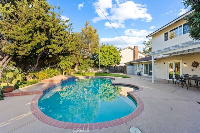 view of pool featuring a fenced in pool, fence, a patio, and french doors