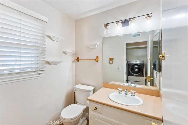 half bath with toilet, visible vents, washer / clothes dryer, and vanity