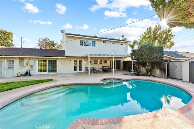 rear view of property featuring a fenced in pool, french doors, stucco siding, a patio area, and a fenced backyard