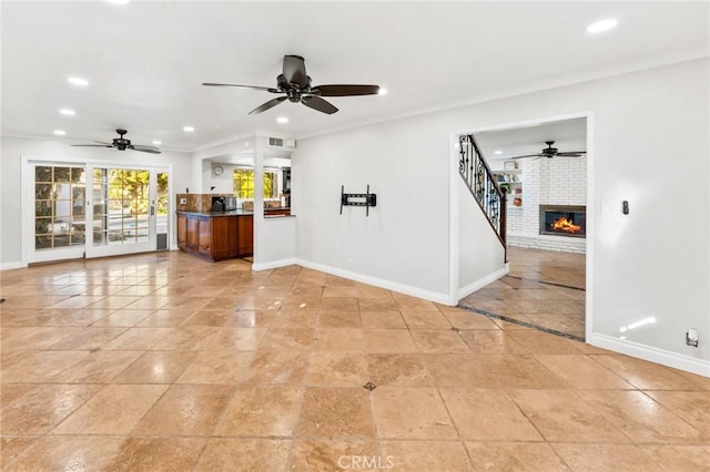 unfurnished living room with baseboards, a brick fireplace, recessed lighting, and crown molding