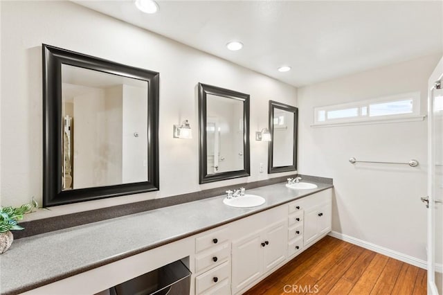 full bathroom with recessed lighting, wood finished floors, a sink, and double vanity