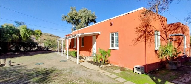 view of side of home with a patio and stucco siding