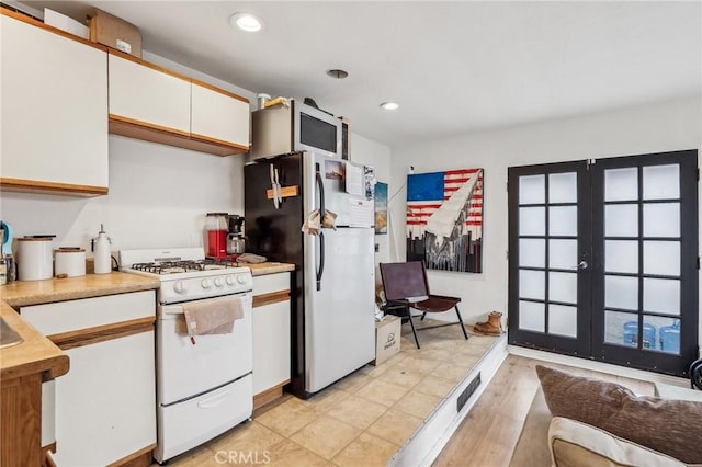 kitchen featuring light countertops, white appliances, white cabinetry, and recessed lighting