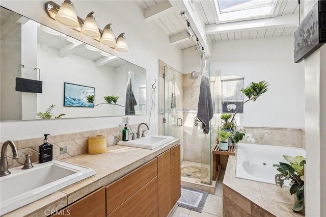 full bathroom with a skylight, a whirlpool tub, a sink, and beamed ceiling