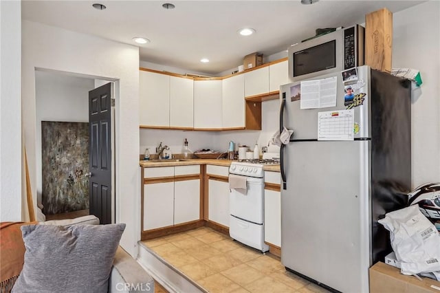 kitchen featuring stainless steel appliances, recessed lighting, light countertops, and a sink