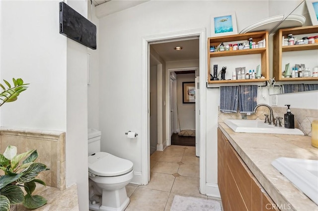 bathroom with tile patterned flooring, a sink, toilet, and double vanity