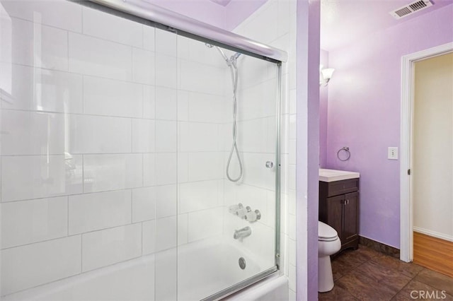 full bath with enclosed tub / shower combo, toilet, vanity, visible vents, and baseboards