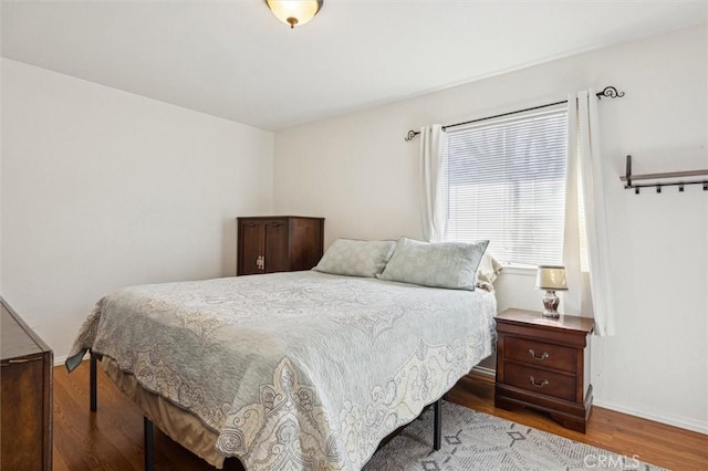 bedroom featuring wood finished floors and baseboards