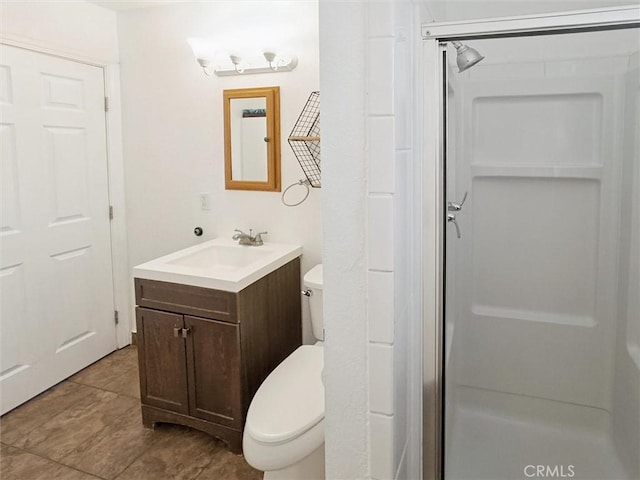 full bathroom featuring toilet, a stall shower, and vanity