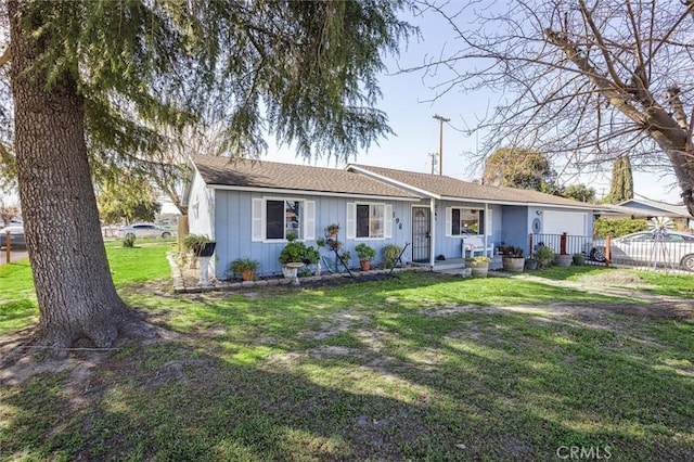 ranch-style house with a front lawn, board and batten siding, an attached garage, and fence