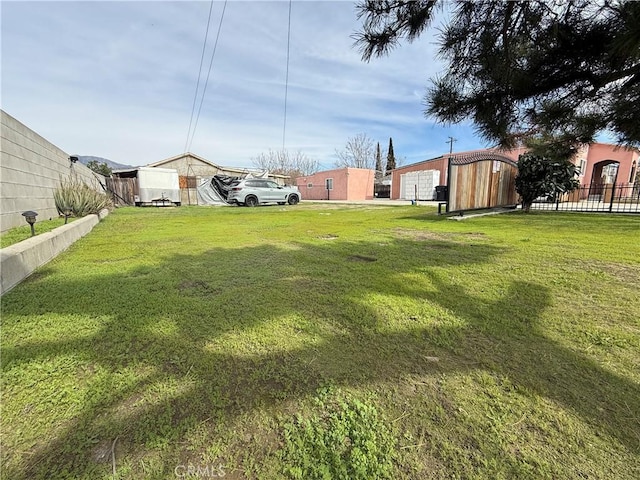 view of yard with an outbuilding and fence