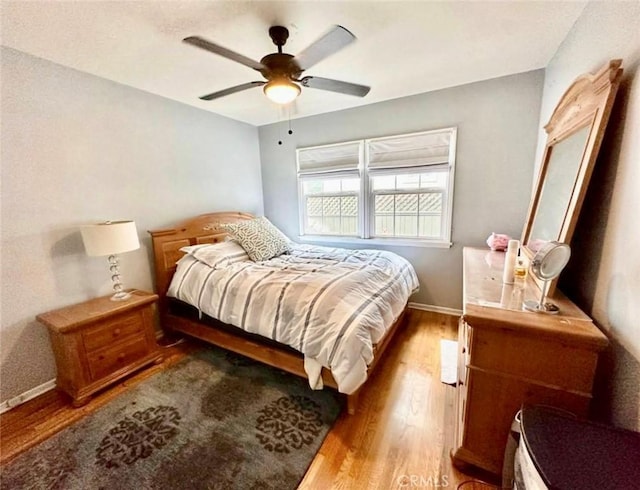 bedroom with wood finished floors, baseboards, and ceiling fan