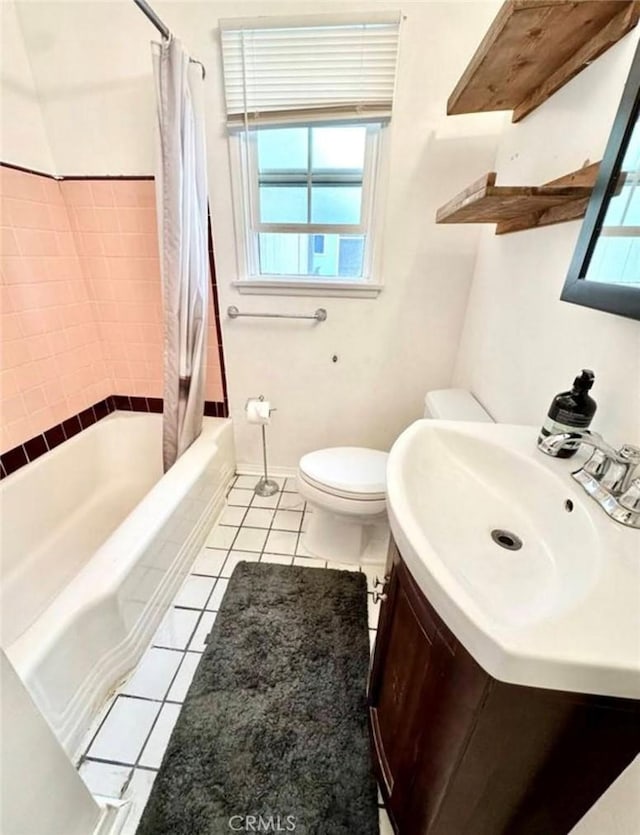 bathroom featuring toilet, shower / bath combo, tile patterned flooring, baseboards, and vanity