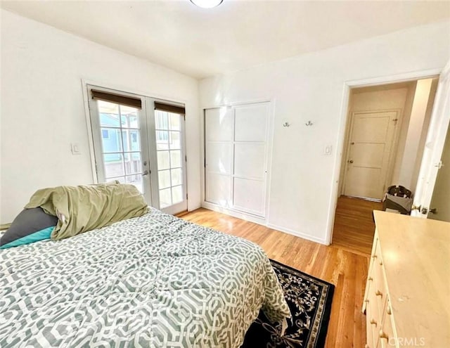 bedroom with access to exterior, light wood finished floors, french doors, and baseboards