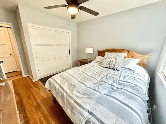 bedroom with wood finished floors, a closet, and ceiling fan