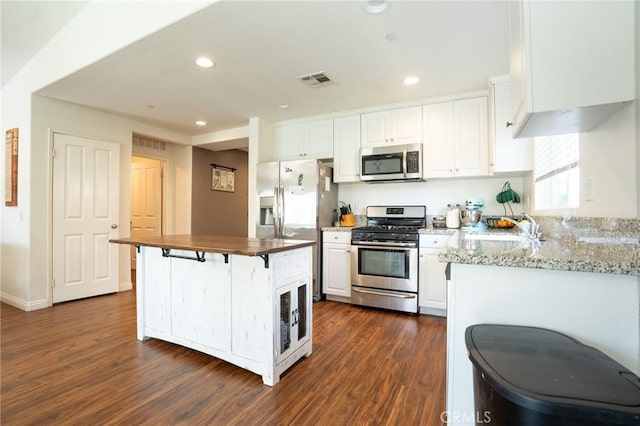 kitchen featuring recessed lighting, stainless steel appliances, dark wood-style flooring, visible vents, and white cabinetry