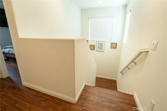 staircase featuring baseboards and wood finished floors