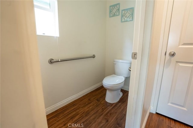 bathroom featuring wood finished floors, toilet, and baseboards