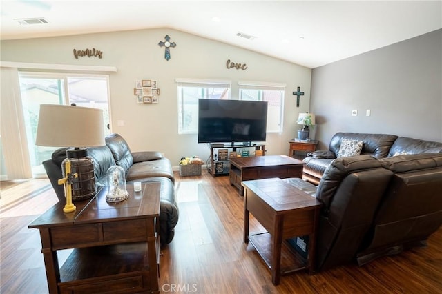 living room featuring plenty of natural light, visible vents, and vaulted ceiling