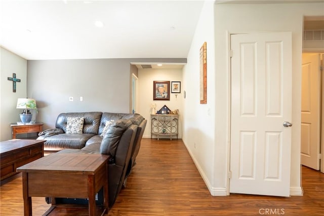 living room featuring visible vents, baseboards, and wood finished floors