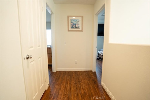 corridor featuring dark wood-style floors and baseboards