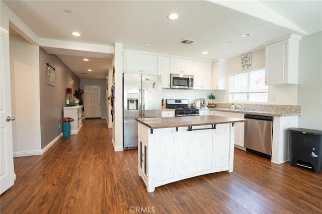 kitchen featuring appliances with stainless steel finishes, white cabinets, and dark wood-style floors