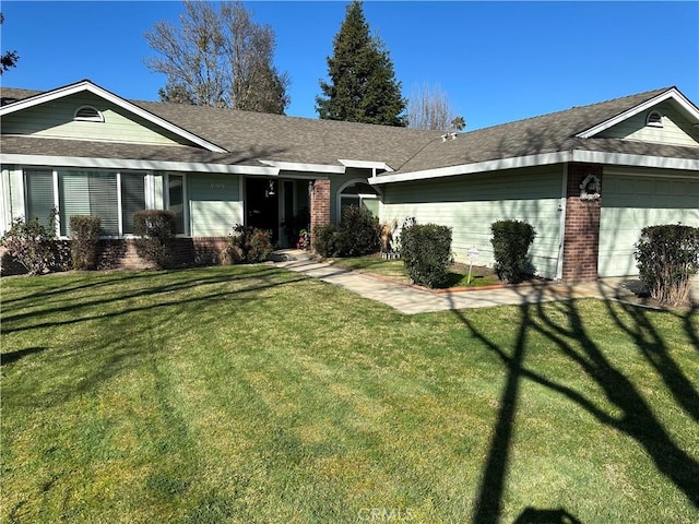 ranch-style house with a garage, a front lawn, a shingled roof, and brick siding