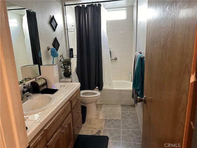 bathroom with toilet, vanity, shower / bath combo with shower curtain, and a textured wall