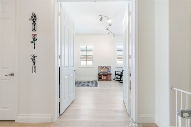 hallway featuring light wood-style floors and baseboards