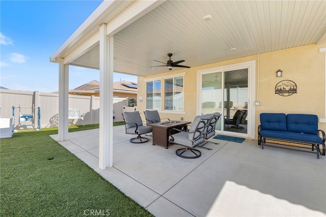 view of patio / terrace with a fire pit, fence, and a ceiling fan