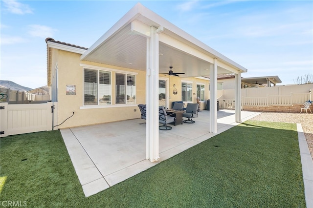 back of house with a patio area, ceiling fan, fence, and stucco siding