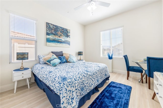 bedroom featuring light wood-type flooring, baseboards, and a ceiling fan