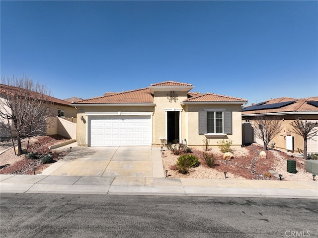 mediterranean / spanish-style home with concrete driveway, a tiled roof, an attached garage, fence, and stucco siding