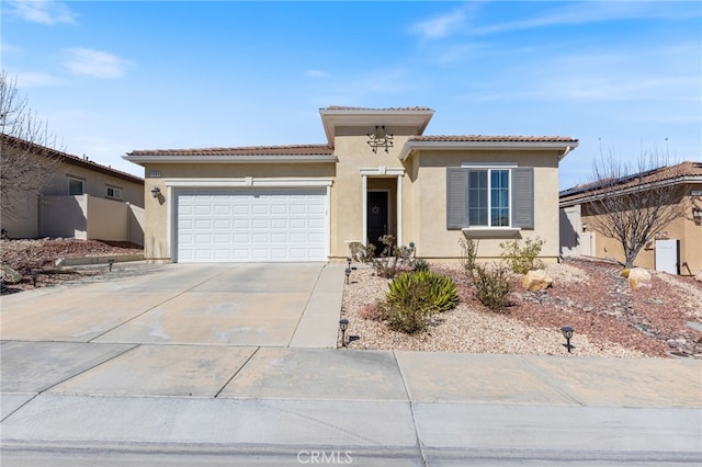 view of front of house with driveway, a tiled roof, a garage, and stucco siding