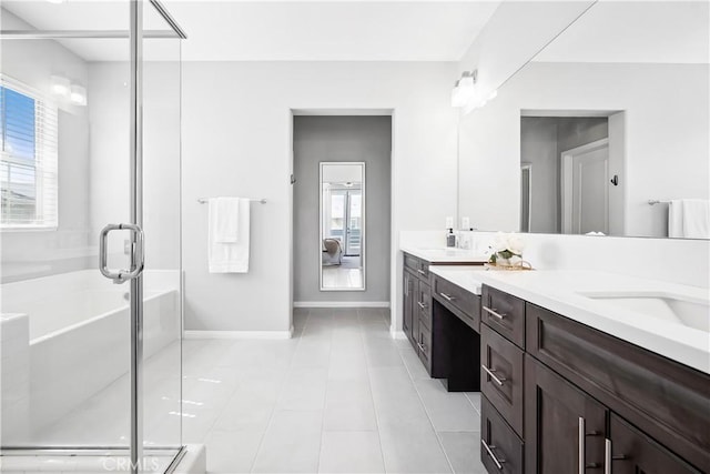 bathroom with double vanity, a stall shower, baseboards, a tub, and tile patterned floors