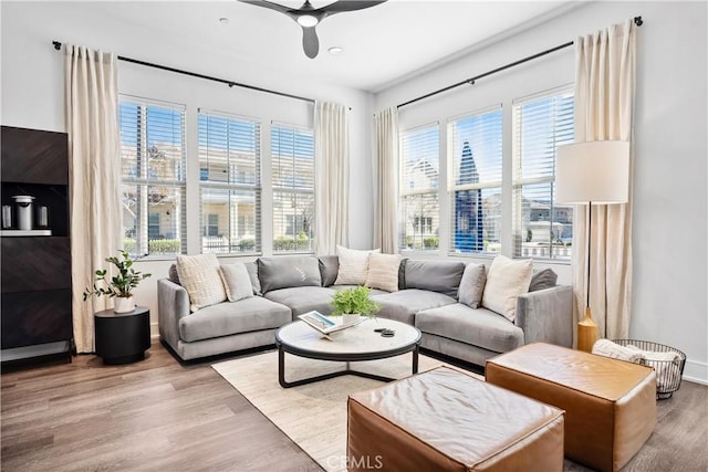 living room with ceiling fan, wood finished floors, and baseboards