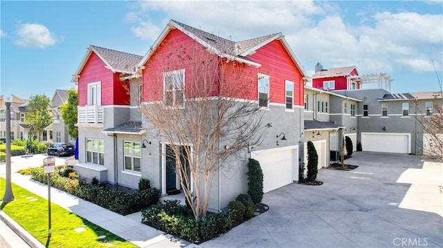 view of front of house featuring an attached garage, a residential view, and stucco siding