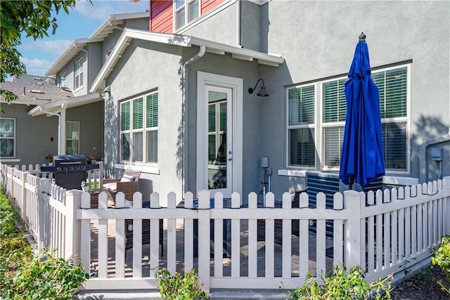 view of side of home with fence and stucco siding