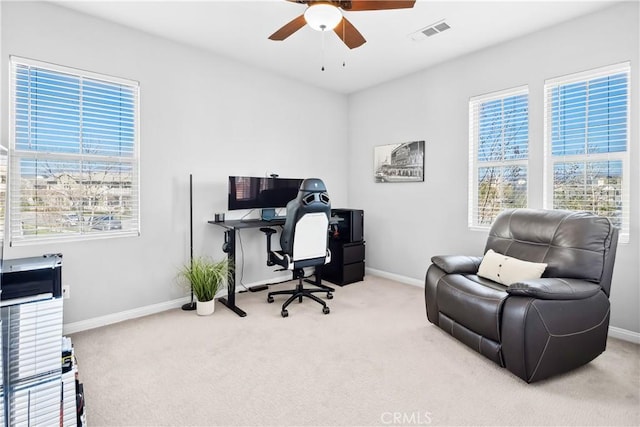 carpeted home office featuring plenty of natural light, visible vents, ceiling fan, and baseboards