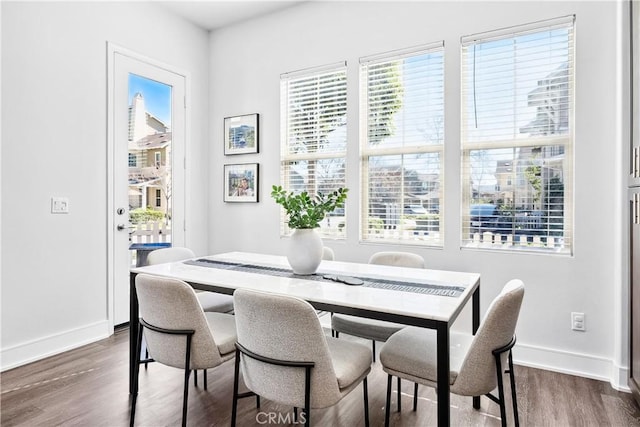 dining space with a healthy amount of sunlight, baseboards, and dark wood finished floors