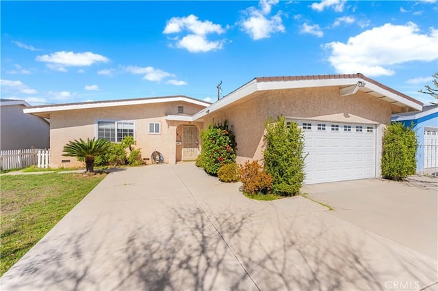 single story home featuring a garage, driveway, fence, a front lawn, and stucco siding